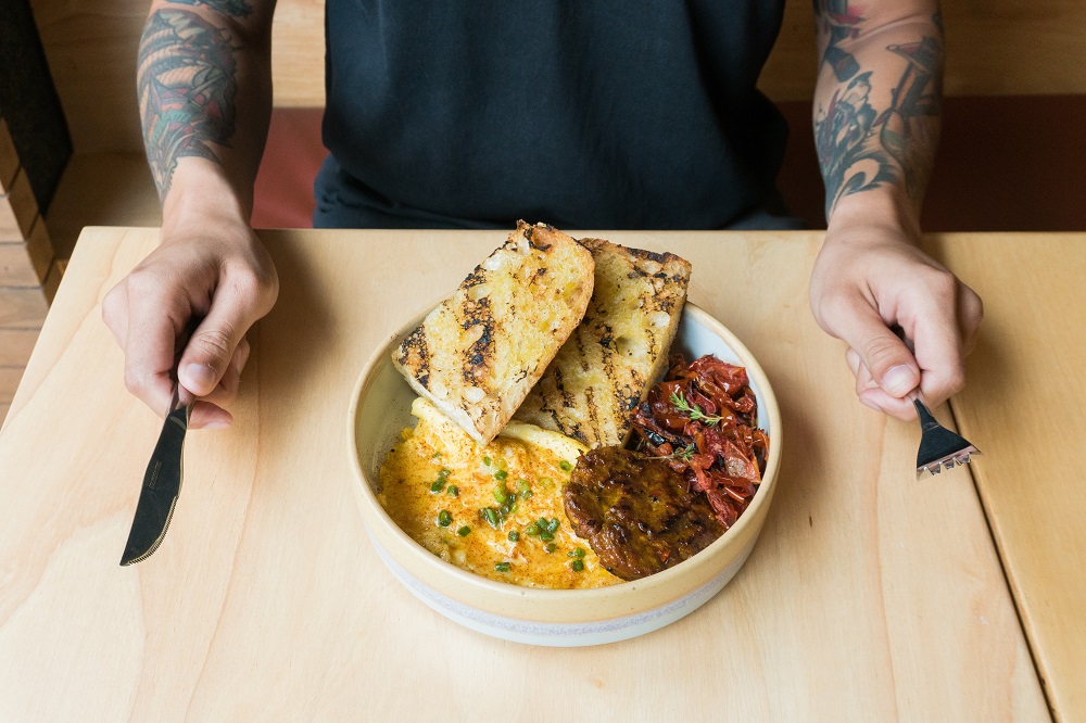 A customizable ‘breakfast bowl’ featuring grilled focaccia, scrambled egg, sai-ua patty and roasted tomatoes. Photo: Coconuts