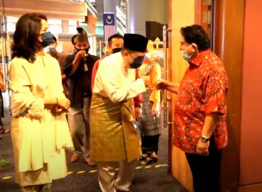 Adnan Mansor, in red, gives a fist bump to a wedding guest at the entrance. Photo: Video2U Productions/ YouTube