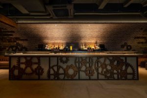 Visualization of the glass-paneled bar with exposed brass pipes. Image: Rails
