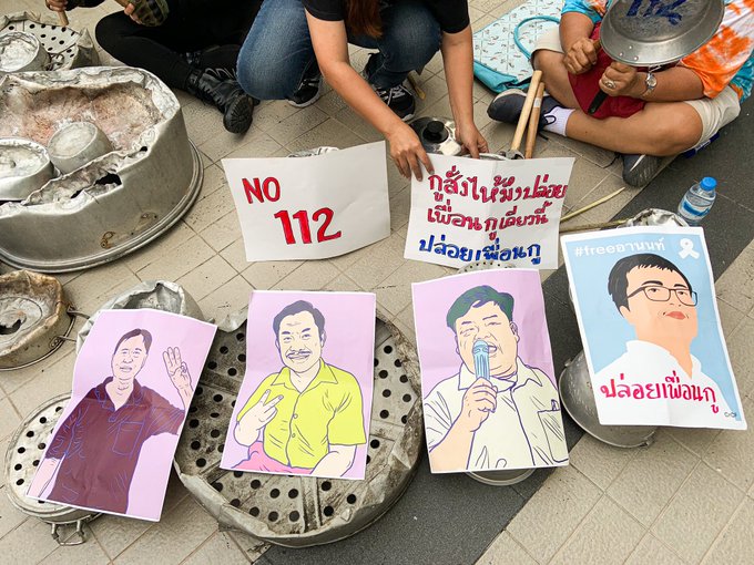 Pro-democracy protesters on Feb. 10 present portraits of detained four activists — Somyot Prueksakasemsuk, Patiwat “Bank” Saraiyaem, Parit “Penguin” Chiwarak and Arnon Nampa — in front of the Bangkok Art and Culture Centre as they shout “Release our friends.” Photo: Coconuts