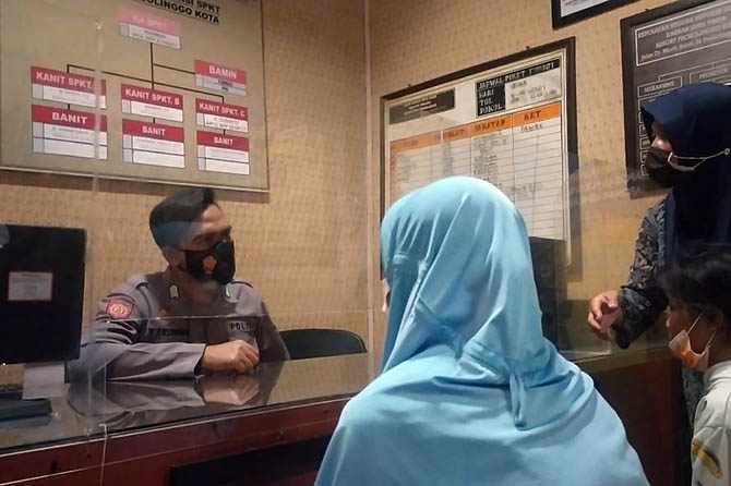 Domestic worker Pariyem (in blue veil) reporting her alleged abuse by her former employers to the police in Probolinggo, East Java. Photo: Istimewa