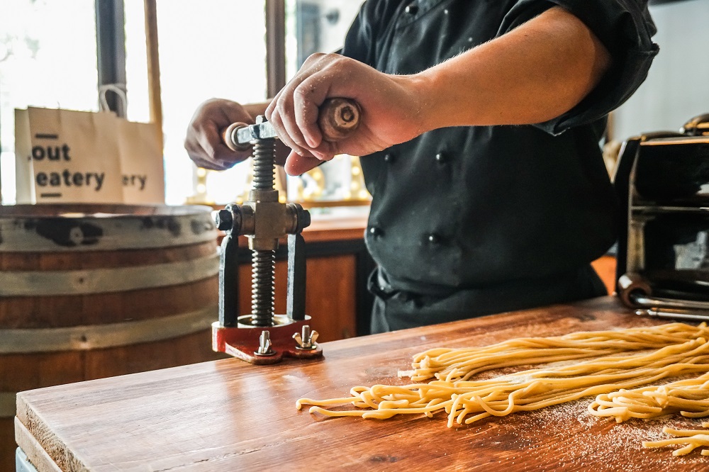 An About Eatery employee uses the bigolaro pasta maker. Photo: Coconuts