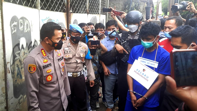 The 21-year-old man, dressed in blue shirt, was arrested this week for allegedly killing two women in the span of two weeks. Photo: Istimewa via Kumparan