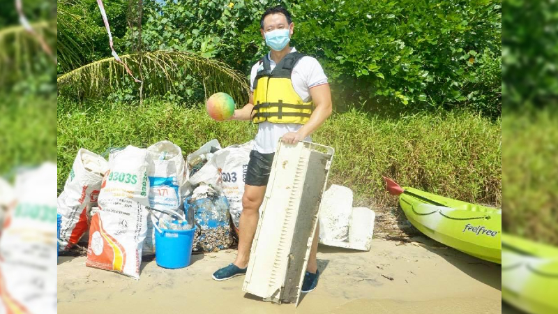 MP Louis Ng posing with a ball and aircon unit from a beach cleanup yesterday. Photo: Louis Ng/Facebook
