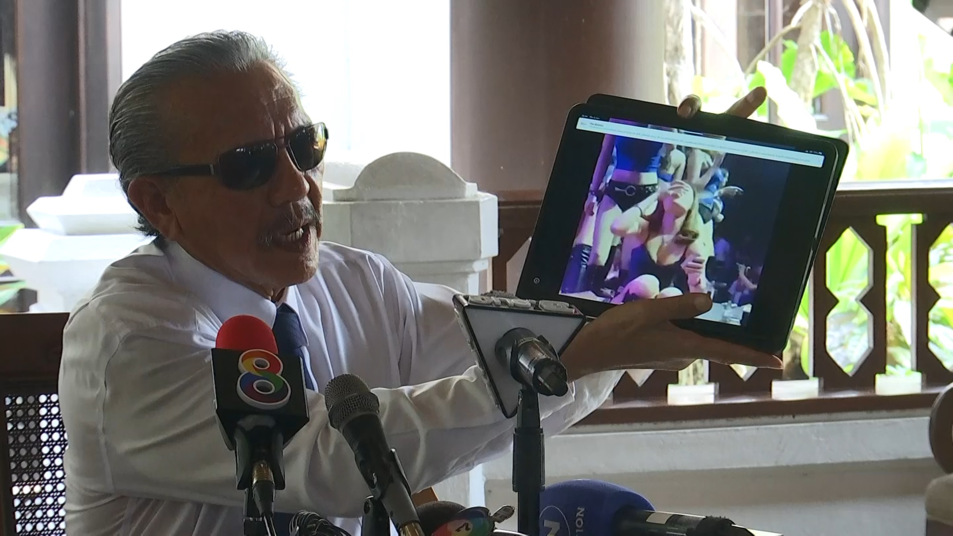 Former politician Chuvit Kamolvisit shows a video clip of showgirls at the Krystal Club on Thursday at a news conference.
