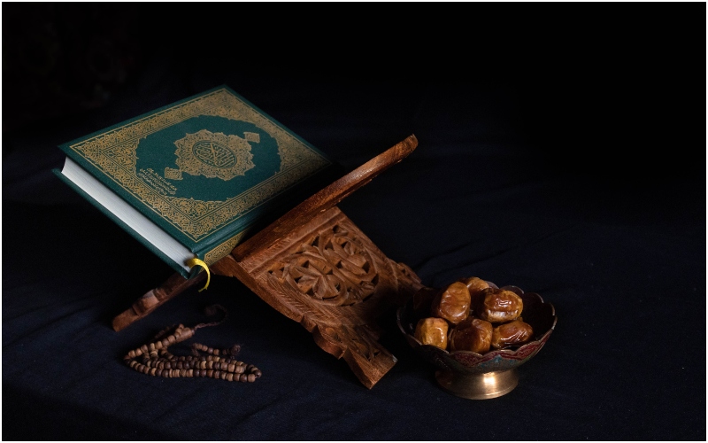 A Quran beside a bowl of dates. Photo: Abdullah Arif/Unsplash