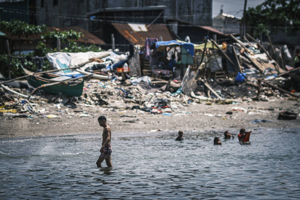 Teens swimming in the slums of Manila City. Photo: Luis Liwanag