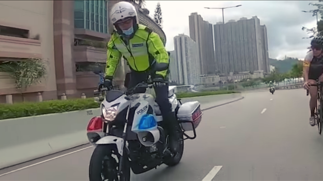 The viral video shows the traffic cop half-standing on his bike’s pedals and rocking his hips back and forth. Screenshot: Facebook/HK Bikers Hub