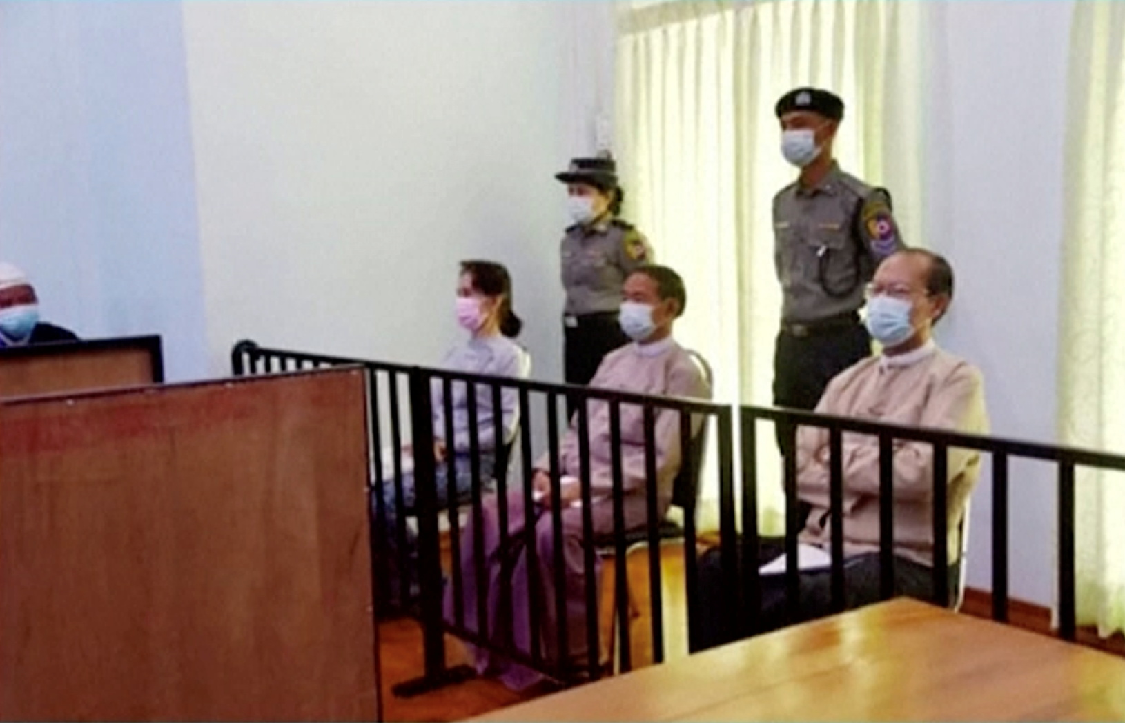 File photo of ousted State Counsellor Aung San Suu Kyi, seated at left, alongside former president Win Myint and doctor Myo Aung appear at a court in Naypyitaw, Myanmar, on May 24, 2021. Image: MRTV