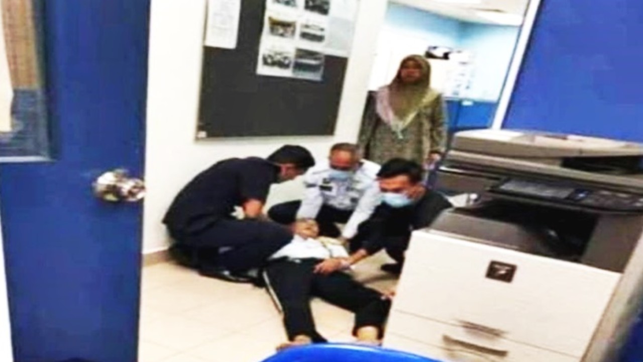 A police officer lying on the ground as three others attended to him. Photo: Nazaruddin Yusoff