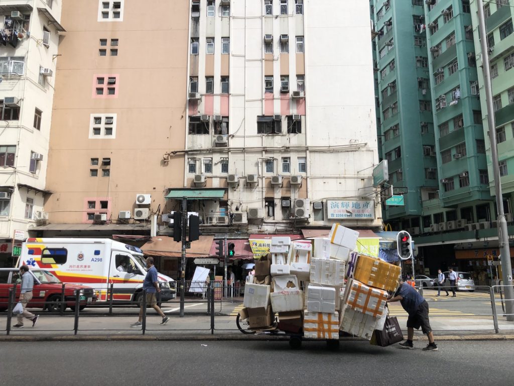 An elderly woman pushes a cart of styrofoam boxes along To Kwa Wan Road. Photo: Coconuts Media