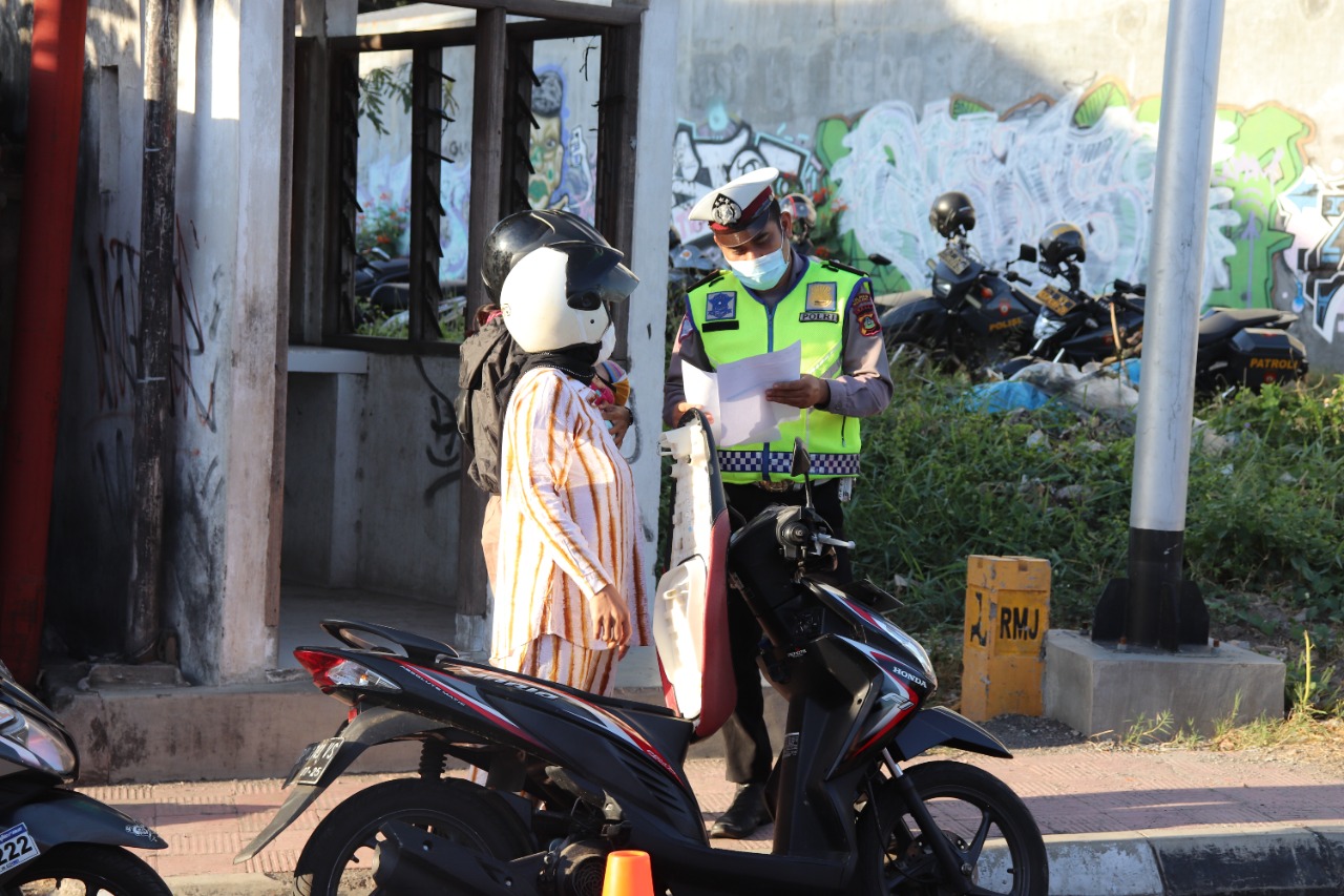 A police officer checking papers required to travel between regions in Bali during Emergency PPKM. Photo: Buleleng Police