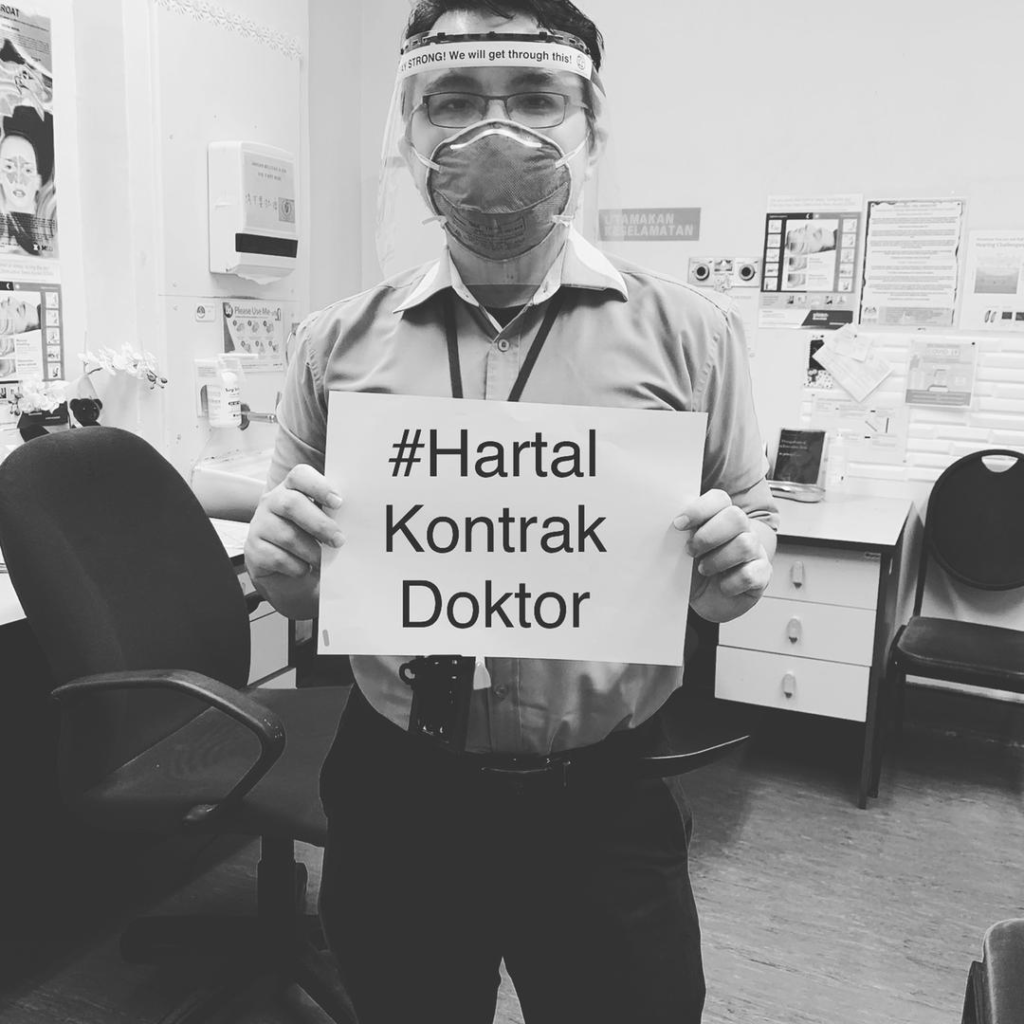 A doctor poses with a sign that says '#HartalKontrakDoktor.' Photo: HartalKontrakDoktor/Twitter