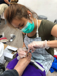 Cass Ng trims a senior citizen's toenails at HKL3C Life Commitment Charity Club. Photo: Supplied