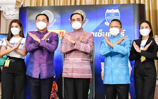 Thai PM Prayuth Chan-ocha and government authorities make a symbolic gesture warning people to be aware of scammers.