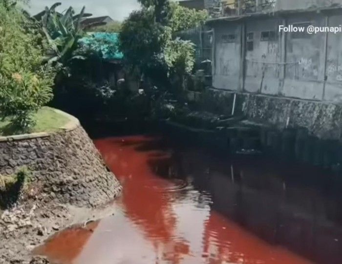 A video went viral on April 7, 2022, showing a river in Denpasar turned red due to waste from a tie-dying business nearby. Photo: Screengrab.