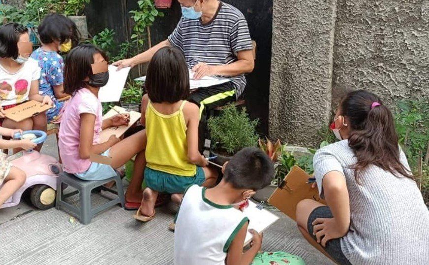 A retired physics teacher has taken to teaching the local kids in his neighborhood in Santa Ana, Manila. Image: Delfin Angeles (Facebook)