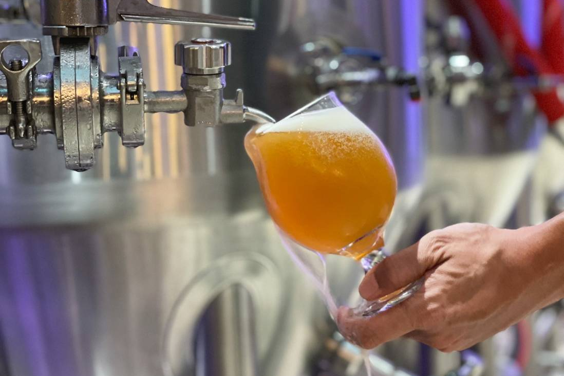 A Helles Lager called Khaosan is poured into a glass from a beer tank at the Bootleg Brothers’ brew pub. Photo: Bootleg Brothers