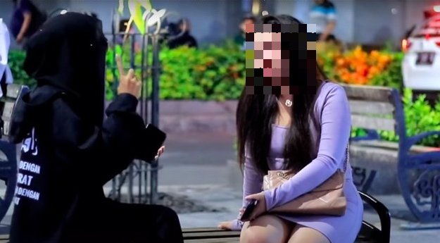 Screengrab from a video in which a YouTuber talked to a stranger and insisted that she cover up in accordance with Islamic rules.