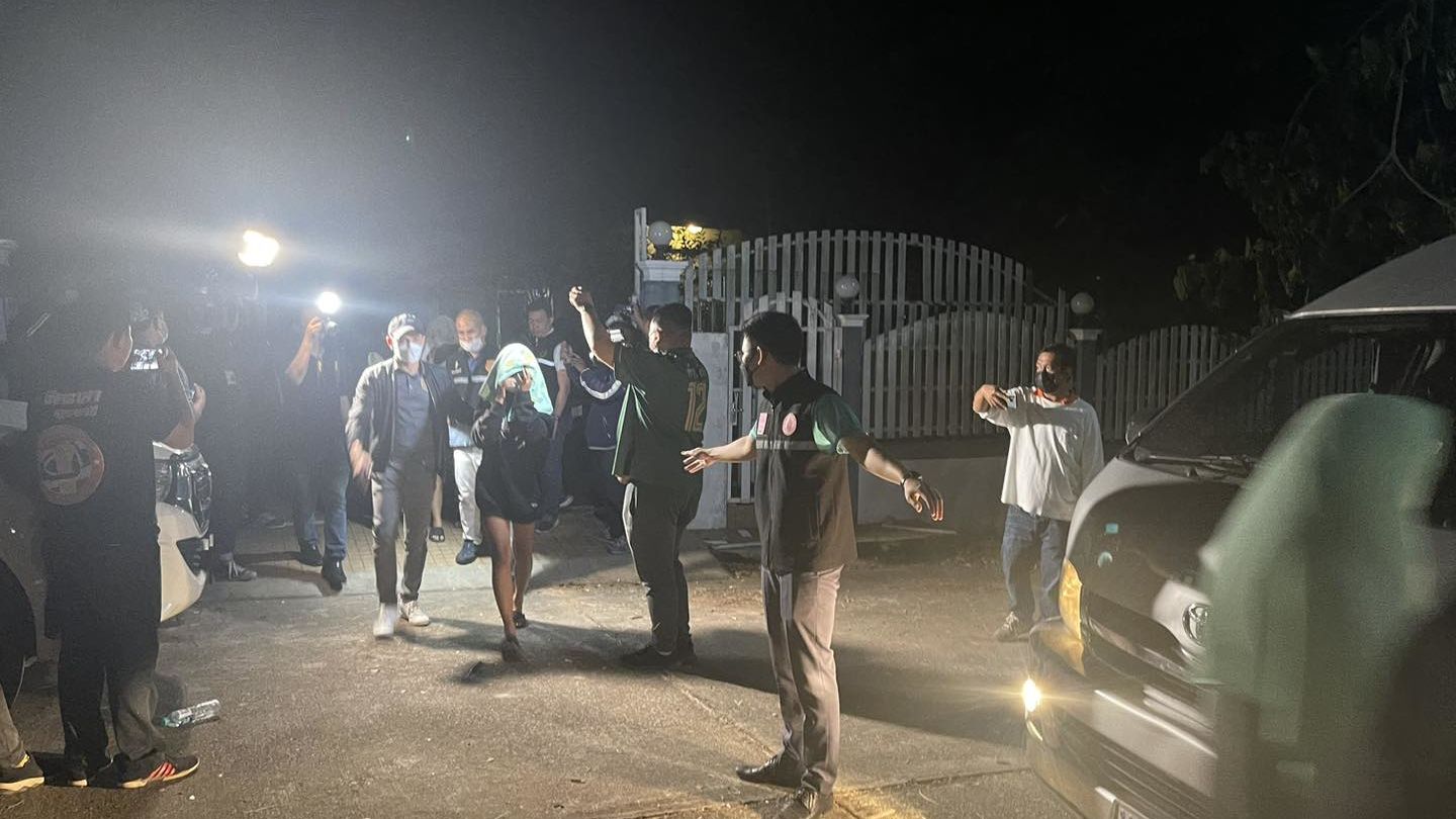De autoriteiten van Udon Thani begeleiden woensdagavond tienermeisjes uit het huis van een man die wordt beschuldigd van het filmen van kinderporno. Foto: Politie Udon Thani