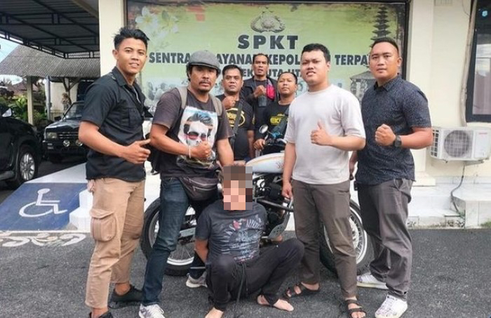 Police officers pose around Englishman GTAW, who is seen squatting in front of a custom motorbike he stole in Canggu on Nov. 28, 2022. Photo: Handout 