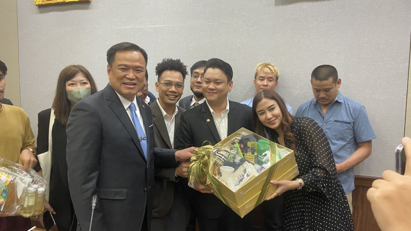 Cannabis entrepreneurs including Soranut ‘Beer’ Masayavanich, in white shirt holding box, presents a box of swag to Health Minister Annutin Charnvirakul on Wednesday afternoon at the Public Health Ministry in Bangkok. Photo: Nicky Tanskul / Coconuts
