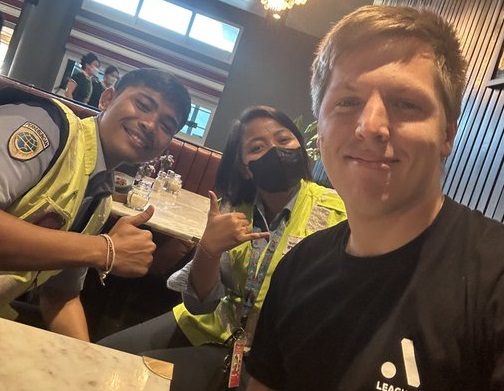 Matt Vandenberg (right) with two Bali Airport officers who accompanied him after he was denied entry to the Island of Gods over minor passport tear.  Uploaded on June 6, 2023. Photo: Twitter @M1D3V.